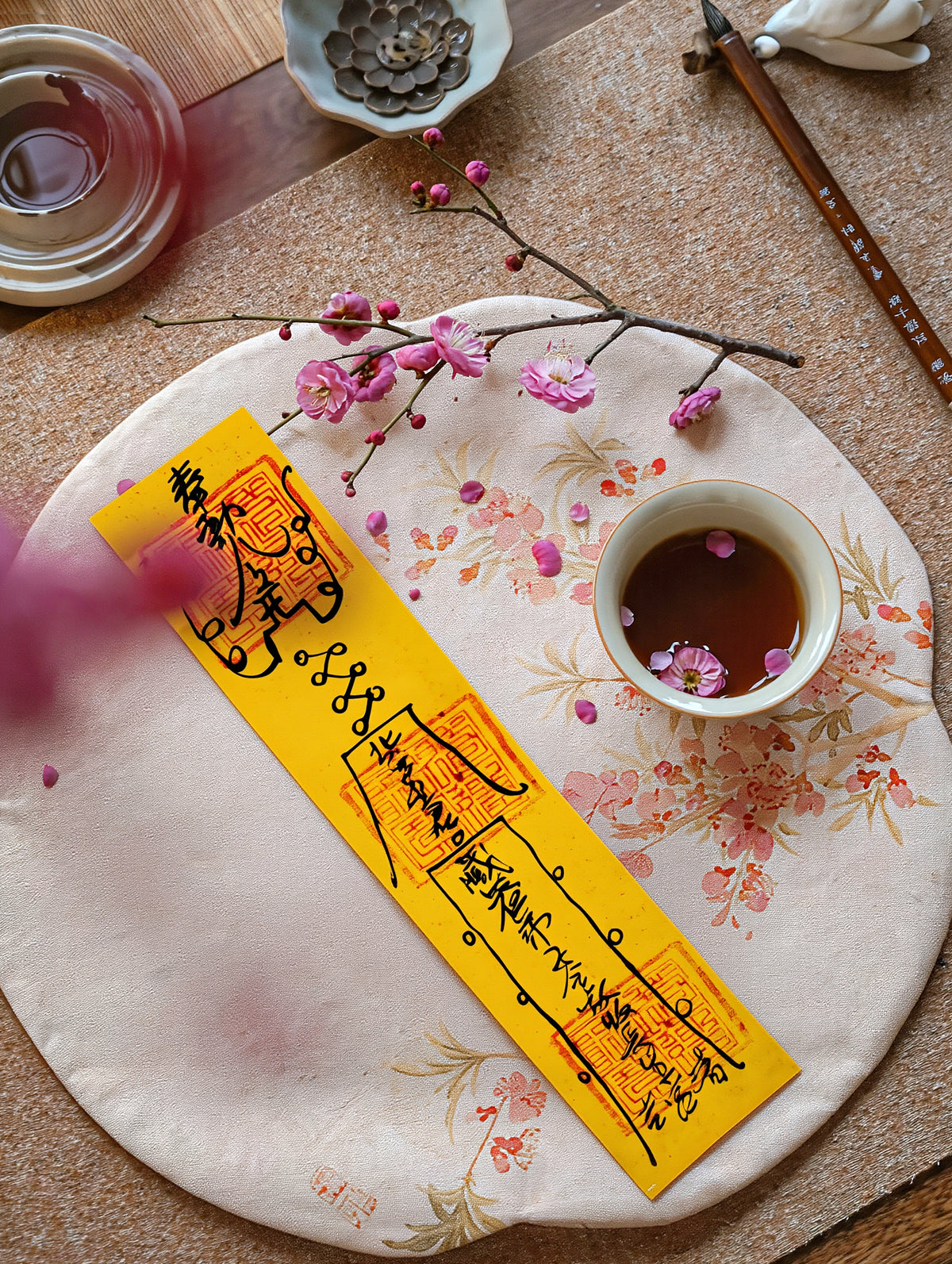 Handcrafted Taoist-inspired love and harmony talisman displayed with tea and floral details.